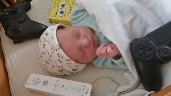 baby met controllers en game dingen eromheen